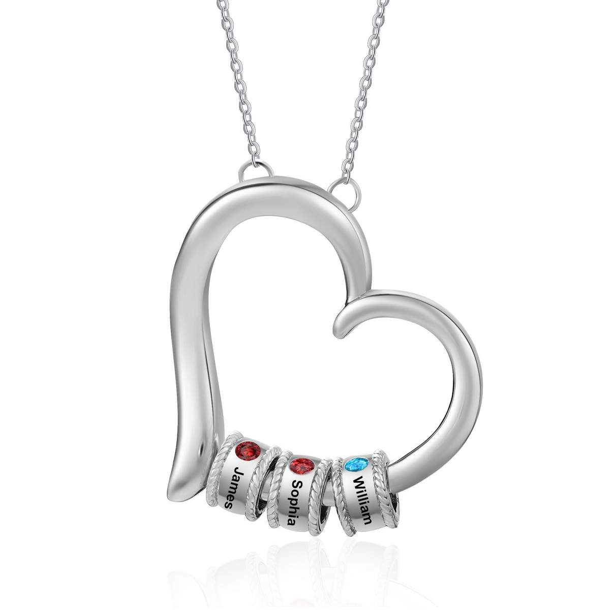 Silver-tone personalized heart necklace engraved with names and set with colored family birthstones, resting on cream fabric